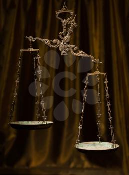 Antique rusty weighing scale on golden background.