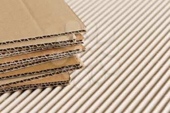 Cardboard pile on corrugated cardboard texture background.