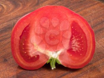 splited red tomato on wooden board