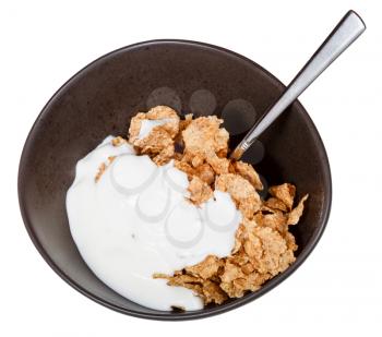 top view of yoghurt and spoon into bowl of cereal isolated on white background