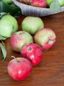 several red and green apples on wooden table close up