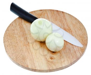 two peeled onions bulbs with ceramic knife on wooden cutting board isolated on white background