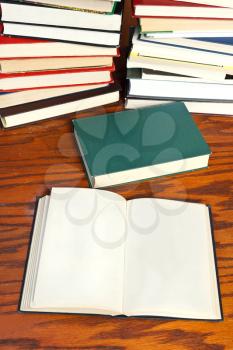 blank open book and closed book on wooden table