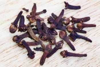 top view of dried clove buds on wooden board