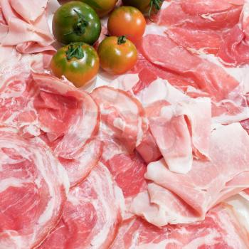 food background from italian prosciutto, pancetta and green tomato