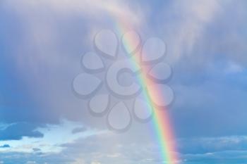 rainbow in autumn blue cloudy sky