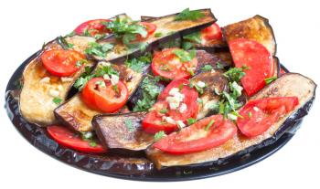 fried eggplants, red tomato and garlic on black plate isolated with white background