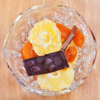 dried fruits and chocolate bar in glass bowl