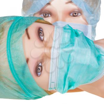 two female dummy doctor heads wearing textile surgical cap and medical protective mask close up