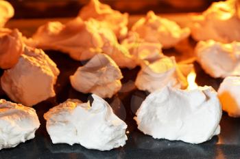 baking of sweet dessert meringue on oven trays close up
