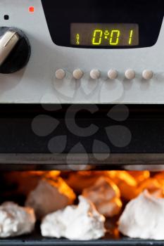 cooking of sweet dessert meringue in oven close up