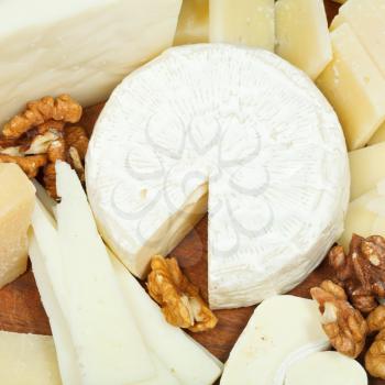 assorted cheeses on wooden plate close up