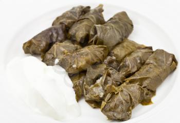 portion armenian meal - dolma from grape leaves and mince on white plate close up