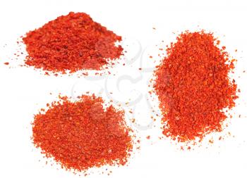 three piles of ground red chili pepper - paprika isolated on white background