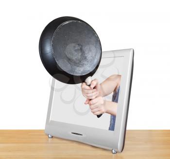 black frying pan in female hands leans out TV screen isolated on white background