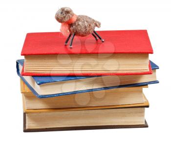 felt soft toy lamb on stack of books isolated on white background