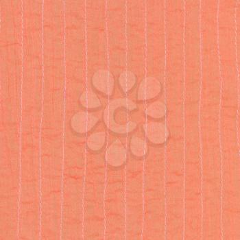 coral color textile background from stitched silk fabric