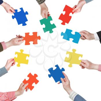 set puzzle pieces in people hands in circle isolated on white background