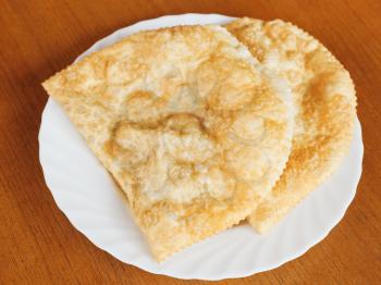 Crimean tatar cuisine - top view of cheburek pie on white plate