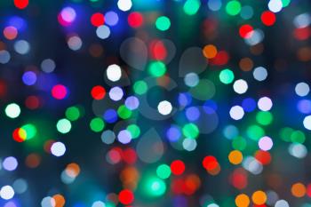 defocused christmas lights in dark night in city