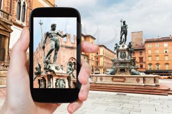 travel concept - tourist taking photo of Piazza Nettuno in Bologna on mobile gadget, Italy