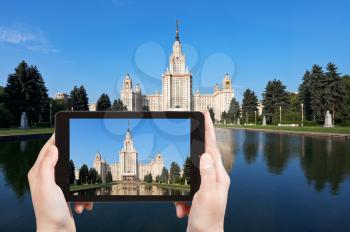 travel concept - tourist taking photo of Lomonosov Moscow State University and fountain pond in summer day on mobile gadget, Russia