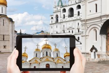 travel concept - tourist taking photo of Cathedral square in Moscow Kremlin on mobile gadget, Russia