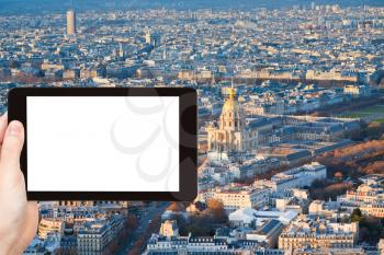 travel concept - tourist photographs Les Invalides building and panorama of Paris, France in winter afternoon on tablet pc with cut out screen with blank place for advertising logo