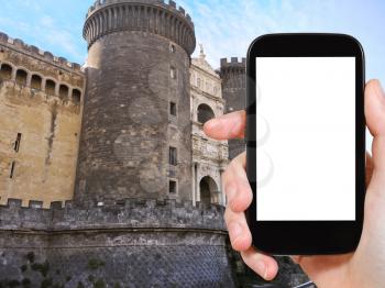 travel concept - tourist photograph New Castle (Castel Nuovo, Maschio Angioino) medieval castle in Naples, Italy on smartphone with cut out screen with blank place for advertising logo