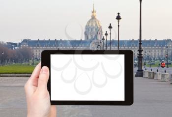 travel concept - tourist photograph Hotel des invalides in Paris, France in evening on tablet pc with cut out screen with blank place for advertising logo