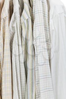 various shirts on hangers in wardrobe close up