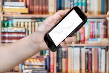 hand holds smart phone with cut out screen in library