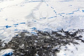 snow and ice at frozen lake in cold winter day