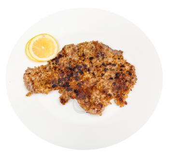top view of fried veal schnitzel and lemon slices on white plate isolated on white background