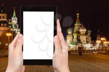 travel concept - tourist photographs Moscow night landscape with Kremlin Cathedral, Vasilevskiy Descent of Red Square on tablet PC with cut out screen with blank place for advertising, Russia