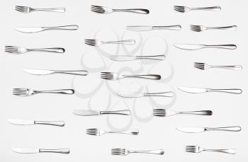 top view of many table knives and forks on white background