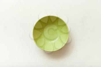 top view of green bowl on white plastering plate