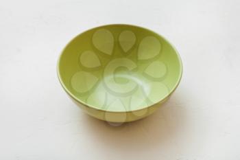 one green bowl on white plastering plate