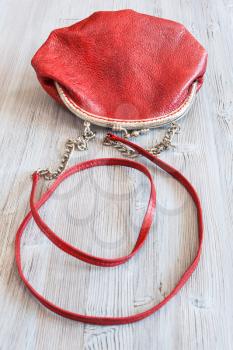 one little red leather women's handbag on wood table