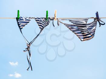 Striped swimsuit is dried on the clothesline outdoors