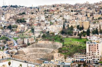 AMMAN, JORDAN - FEBRUARY 18, 2012: above view Amman city with ancient Roman theater from citadel in winter. The Amphitheatre was built the Roman period when the city was known as Philadelphia