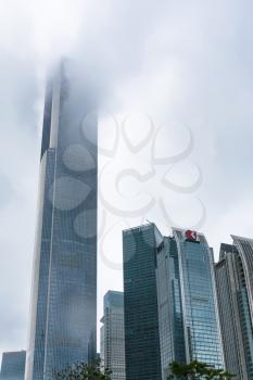 GUANGZHOU, CHINA - MARCH 31, 2017: clouds over modern towers in Zhujiang New Town of Guangzhou city in rainy day. Guangzhou is the third most-populous city in China with population about 13,5 mln