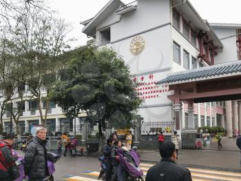 GUILIN, CHINA - MARCH 21, 2017: people near guilin zhonghua primary school on city street in spring. The city is in the northeast of China's Guangxi Zhuang Region, there are about 4,8 mln inhabitants