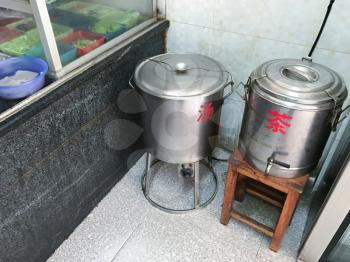 LONGSHENG, CHINA - MARCH 25, 2017: Tanks with hot chicken broth and boiling water in urban eatery in Longsheng town. Longsheng is a small city in the south central Chinese province of Guangxi