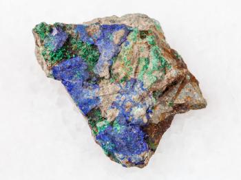 macro shooting of natural mineral rock specimen - blue Azurite and green Malachite on raw stone on white marble background from Ural Mountains, Russia