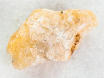 macro shooting of natural mineral rock specimen - yellow Calcite stone on white marble background