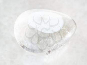 macro shooting of natural mineral rock specimen - polished Rock-crystal gemstone on white marble background
