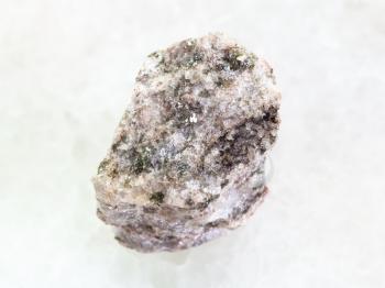 macro shooting of natural mineral rock specimen - rough Apatite ( ore of phosphorus) stone on white marble background