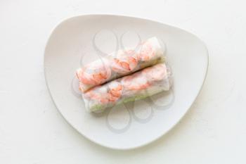 top view of Nem cuon (fresh Vietnamese nem roll with shrimps, mango and ginger) on white plate on white board