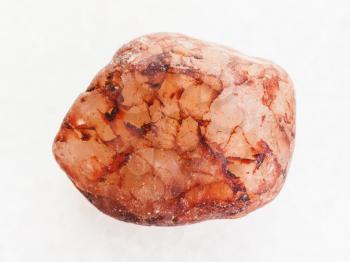 macro shooting of natural mineral rock specimen - raw pink quartz stone on white marble background
